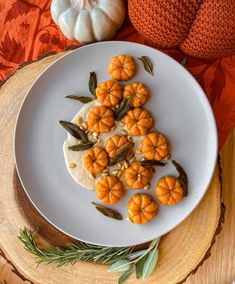 small pumpkins are arranged on a white plate