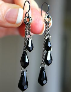 a pair of black and silver dangling earrings