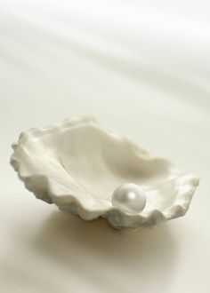 a white bowl with a pearl in it