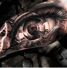 an eye tattoo on the arm with roman numerals and clock faces in it