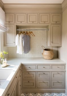 an organized kitchen with white cabinets and drawers