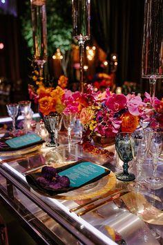 the table is set with flowers and place settings for an elegant dinner or party event