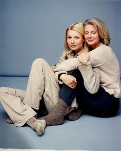 two women sitting on the floor hugging each other