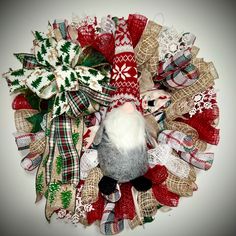 a christmas wreath made out of burlocks and fabric with a stuffed animal in the middle