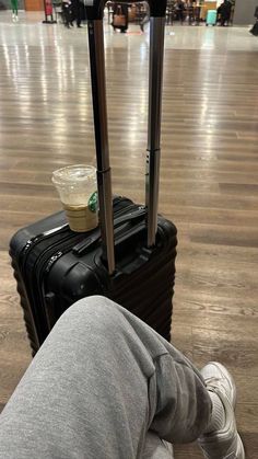 a person laying on the floor with their feet up next to a piece of luggage