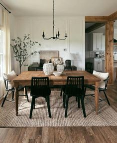 a dining room table with four chairs and a chandelier hanging from the ceiling