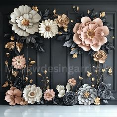 flowers are arranged on the wall in front of black paneled walls with gold and white accents