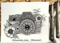 a drawing of a camera with flowers on it and two markers in front of it