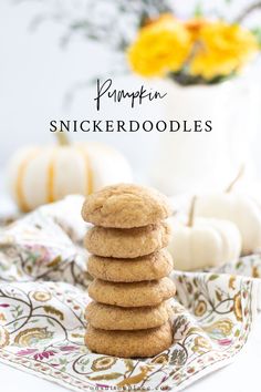 pumpkin spicerdoodles stacked on top of each other in front of white pumpkins