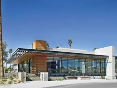 a modern building with palm trees in the background