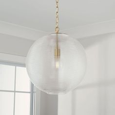 a light fixture hanging from the ceiling in a room with white walls and flooring