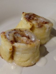 two cinnamon rolls sitting on top of a white plate