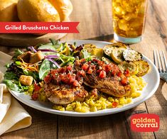 a white plate topped with chicken and veggies next to a glass of beer