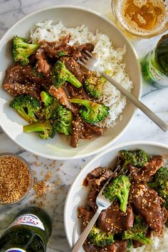 two white bowls filled with beef and broccoli on top of a marble table