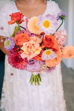 a woman holding a bouquet of flowers in her hands