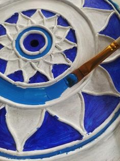 a blue and white circular object with a brush in it's center on a table