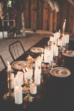 a long table with candles and plates on it