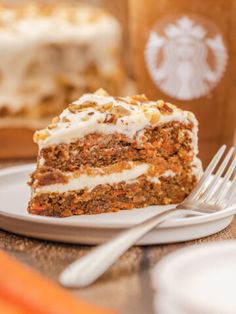 a piece of carrot cake sitting on top of a white plate next to a fork