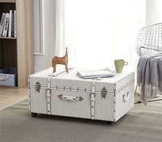 a white trunk sitting on top of a rug in a living room