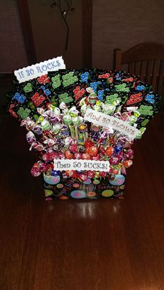 a vase filled with lots of candy on top of a wooden table