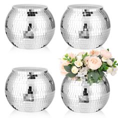 three silver vases with flowers in them