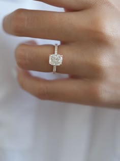 a woman's hand with a diamond ring on it