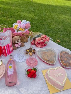 a picnic table covered in pink and white items for valentine's day with heart shaped cakes