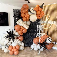 an arrangement of balloons in the shape of stars and bats on a wall with a skeleton