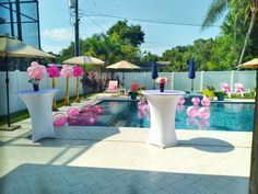 an outdoor pool decorated with pink and white decorations