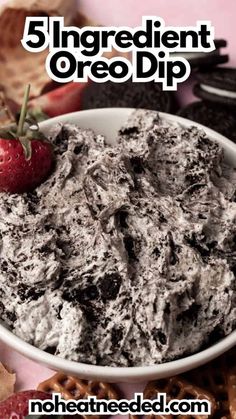 a bowl filled with oreo dip next to crackers and strawberries on the side