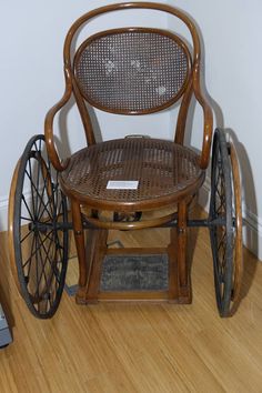 an old wooden chair sitting on top of a hard wood floor next to a wall