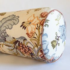 a close up of a pillow on a white surface with a flower pattern in the middle