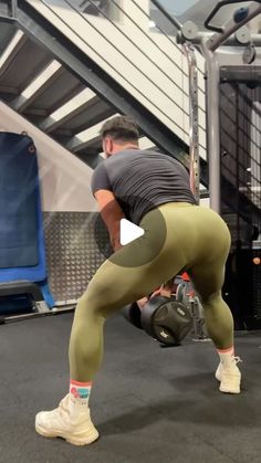 a man doing squats with a kettle in front of him and another person behind him