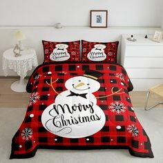 a red and black plaid bed set with a snowman on the front, merry christmas