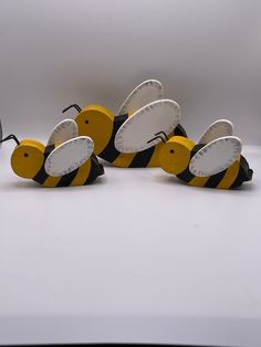 four wooden bees with black and yellow stripes