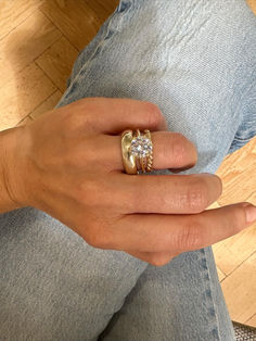 a woman's hand with a gold ring and two diamond rings on her fingers