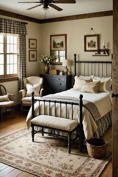 a bed room with a neatly made bed and two chairs next to a window covered in curtains