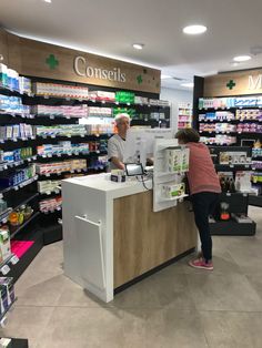 two people standing at the counter in a pharmacy