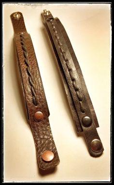 two brown leather handles with buttons on them