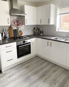 a kitchen with white cabinets and black counter tops