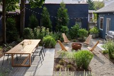 an outdoor patio with tables and chairs in the back yard, surrounded by greenery