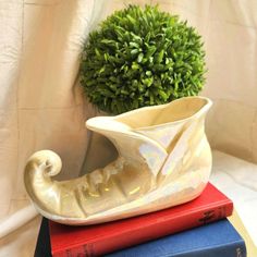 a white vase sitting on top of two books