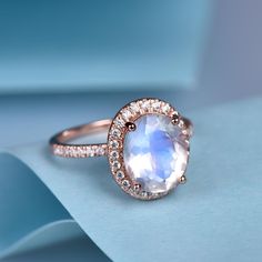 This is a natural moonstone & natural diamond engagement ring.A perfect anniversary gift, birthday gift,wedding engagement ring.Great as a gift or a anniversary ring. Ring Information Stone *10x8mm oval cut Natural moonstone. *0.3ct natural diamond. Metal * Solid 10k 14k &18k. *Color:white gold,yellow gold,rose gold. Custom Order *The main stone can be other gemstones you can imagine,any birthstone can be made.Please contact me if you need this service. *Any size *I can also design the m Elegant Moonstone Anniversary Ring, Moonstone Ring With Halo And Round Cut As Gift, Moonstone Ring With Halo Setting, Moonstone Promise Ring With Halo Setting, Moonstone Diamond Ring For Wedding, Elegant Opal Moon Ring For Anniversary, Elegant Moonstone Diamond Ring For Gift, Elegant Moonstone Crystal Ring With Halo, Gift Moonstone Ring With Halo Setting