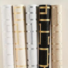 four rolls of black, white and gold paper