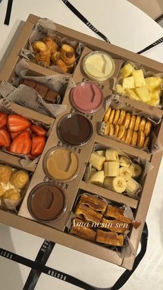 a box filled with lots of different types of food on top of a white table