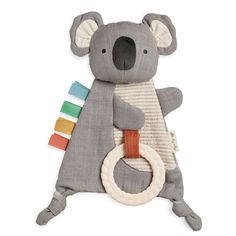 a stuffed koala bear is holding a ring on it's back and wearing a striped bib