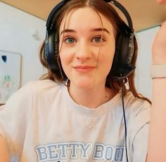 a girl wearing headphones and looking at the camera