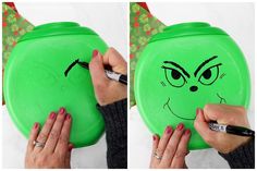 a woman is drawing on a green frisbee with black marker and has her eyes drawn