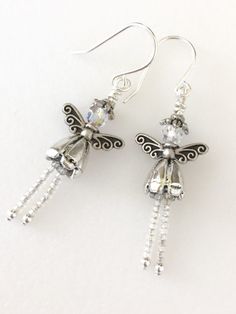 the earrings are decorated with crystal beads and an insect on it's back end