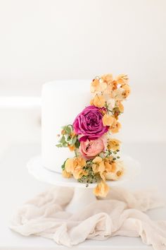 a white cake with yellow and pink flowers on top